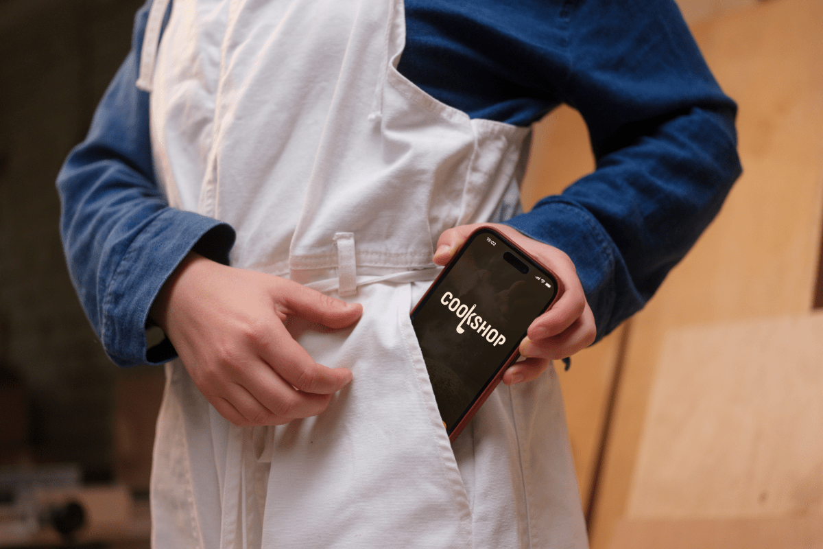 Mockup showing a chef taking a mobile device out of their pocket.